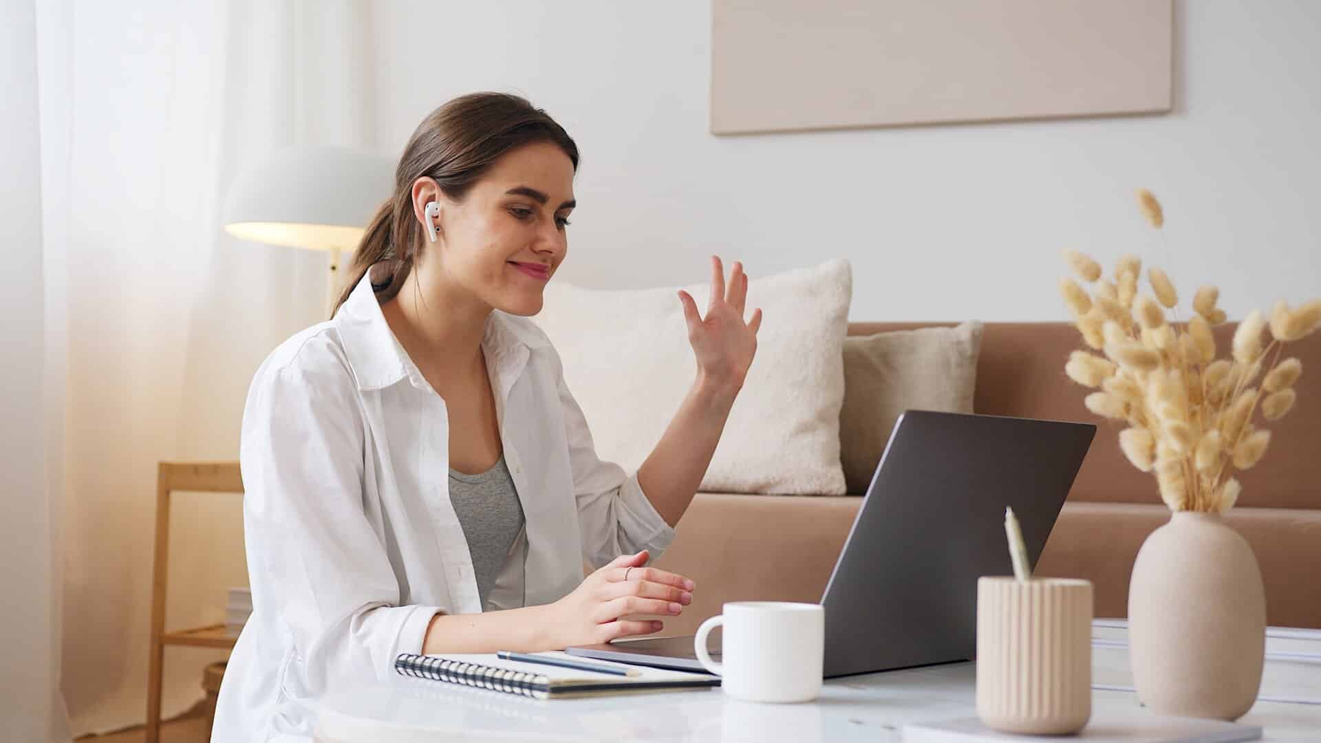 lady sat at her desk, she is looking into a laptop screen, she is in a hearing loss counselling session.