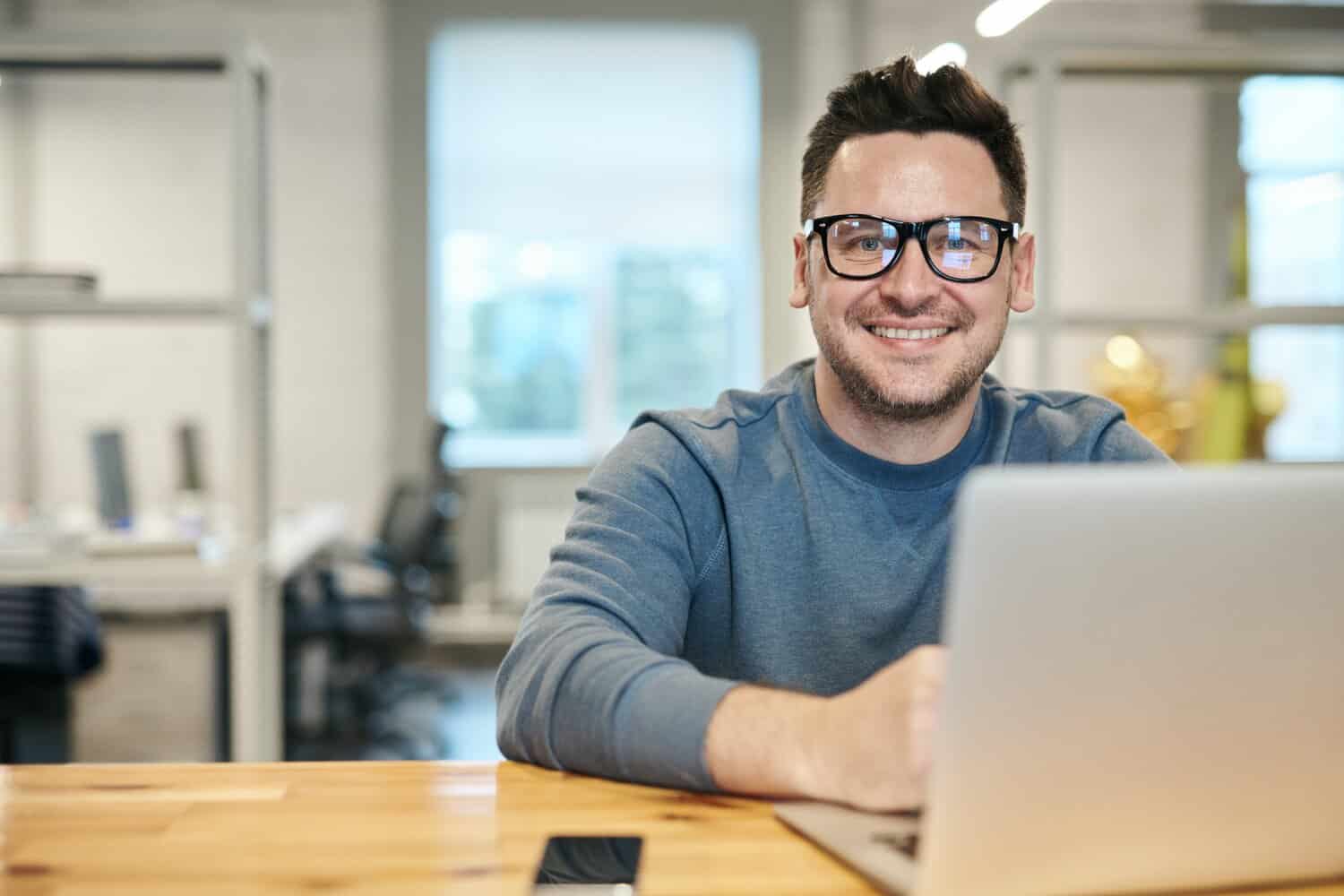 Man sat at his desk looking at his PC, he has just finished a cerebral palsy counselling session.