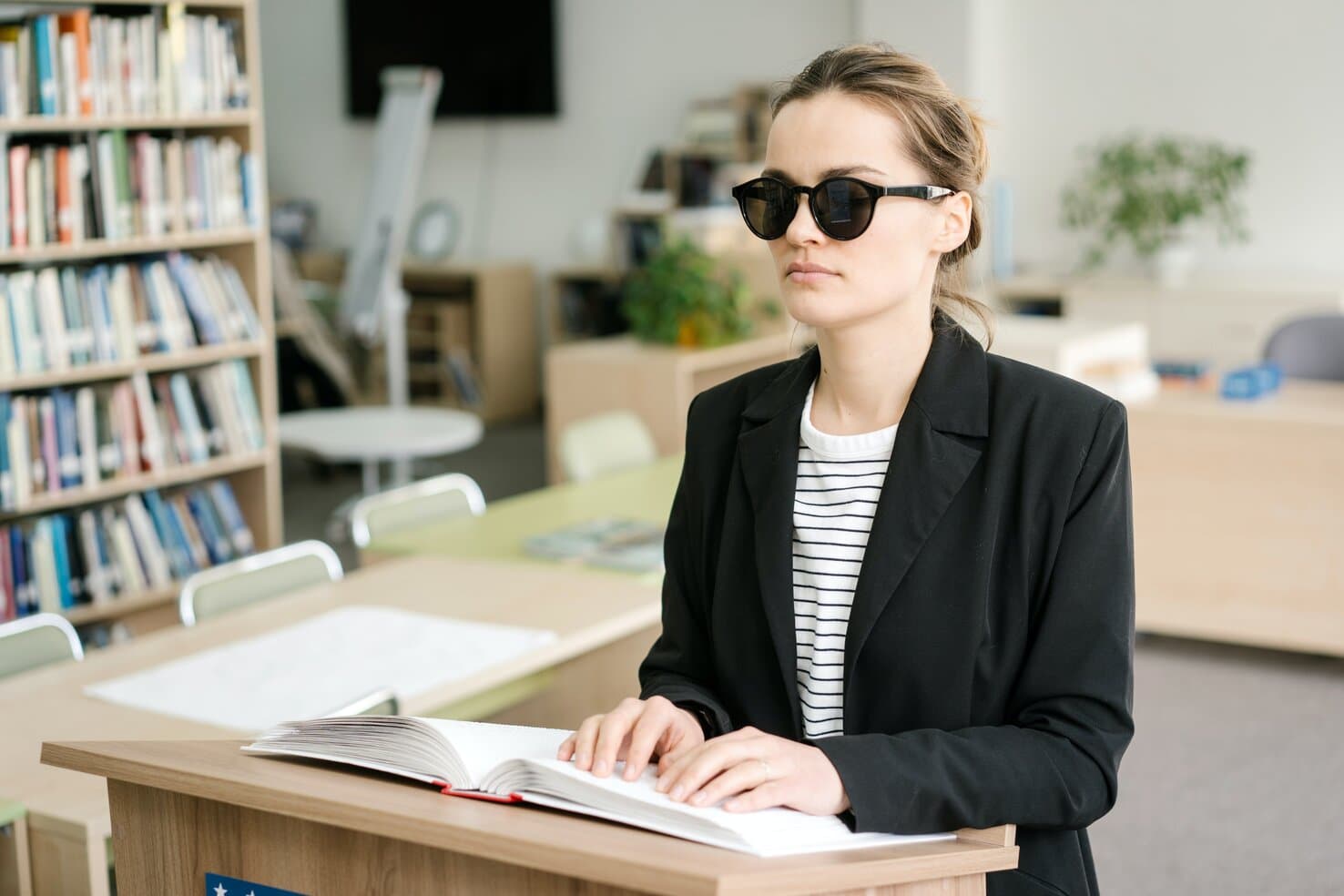 Decorative picture of a lady sat at her desk reading brail.