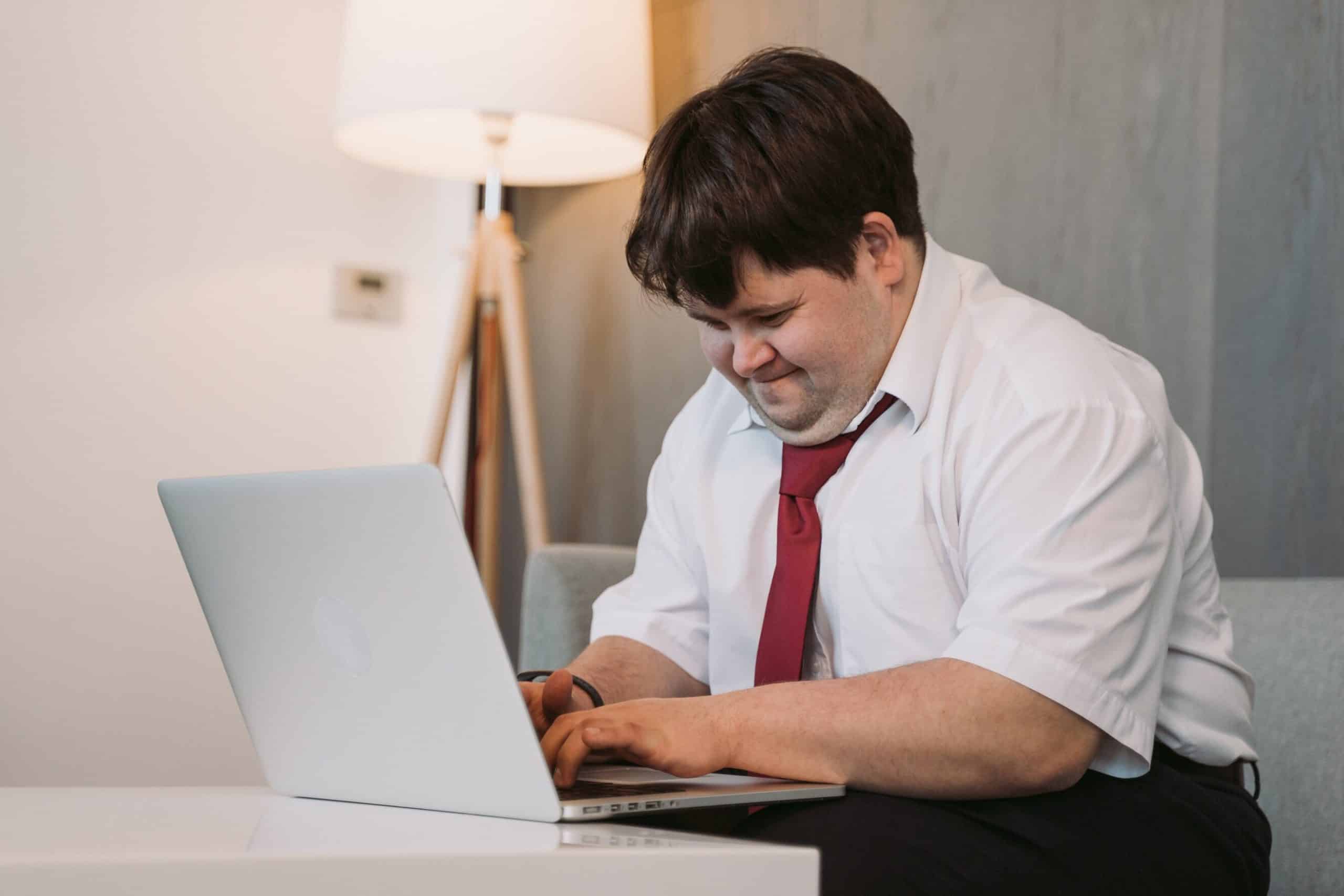 A man sitting on his bed at home, he is in a down's syndrome counselling session