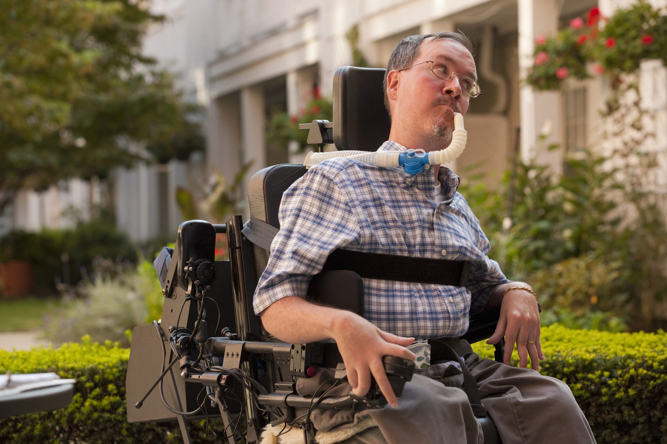 A man sat in his wheelchair with a laptop in front of him. He has had a accident which has resulted to him having spinal cord injury counselling