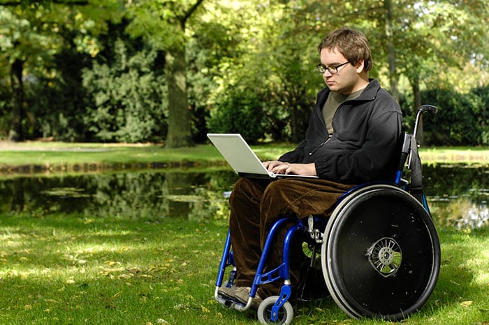 a couple sat on a sofa looking into a Ipad, they are in a Parkinson's Disease counselling session