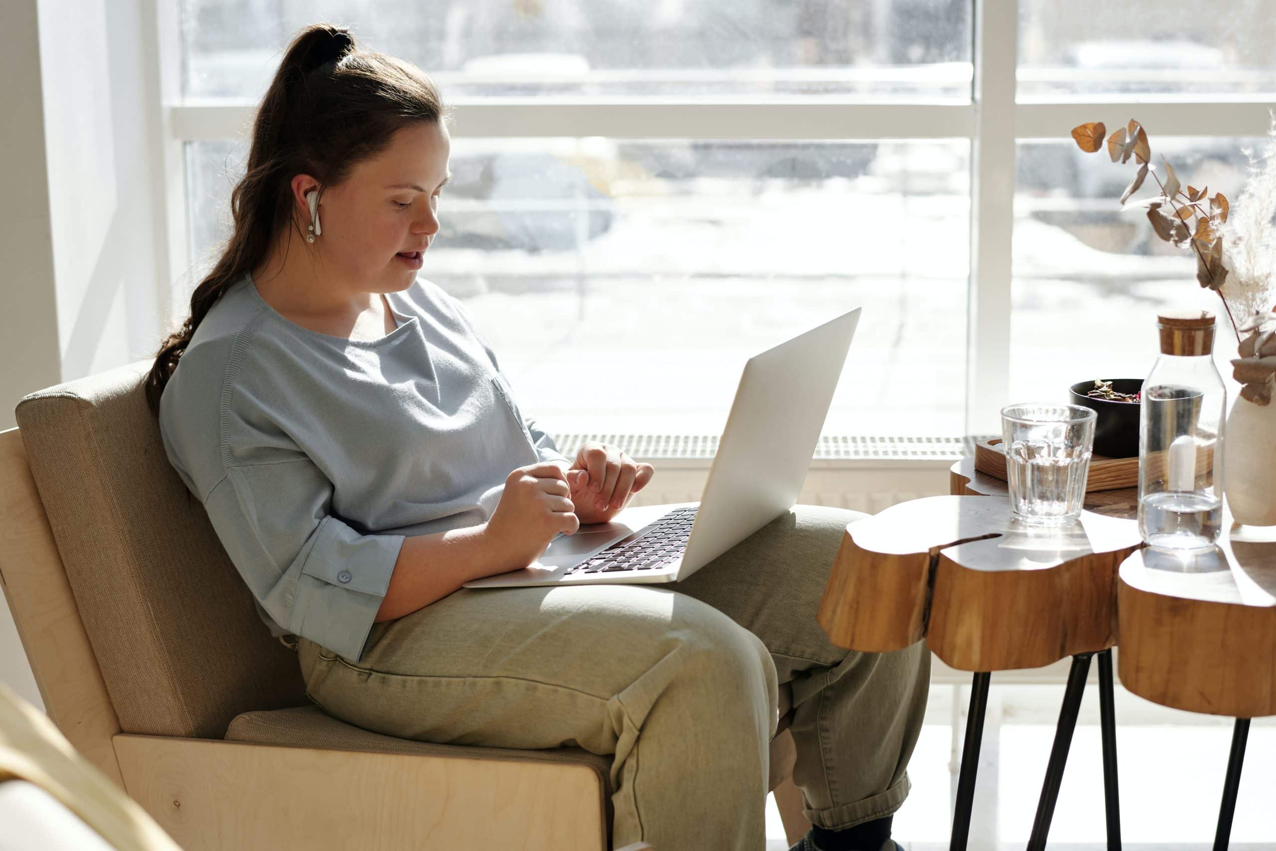 A man sat in his wheelchair with a laptop in front of him. He has had a accident which has resulted to him having spinal cord injury counselling