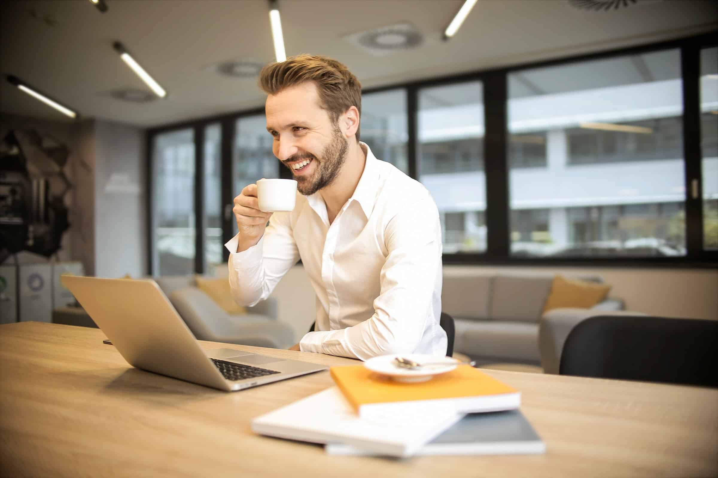 A elderly man in his 60's sat at his desk at home. He has a tie on and looks relaxed. He has started parkinson's disease counselling.