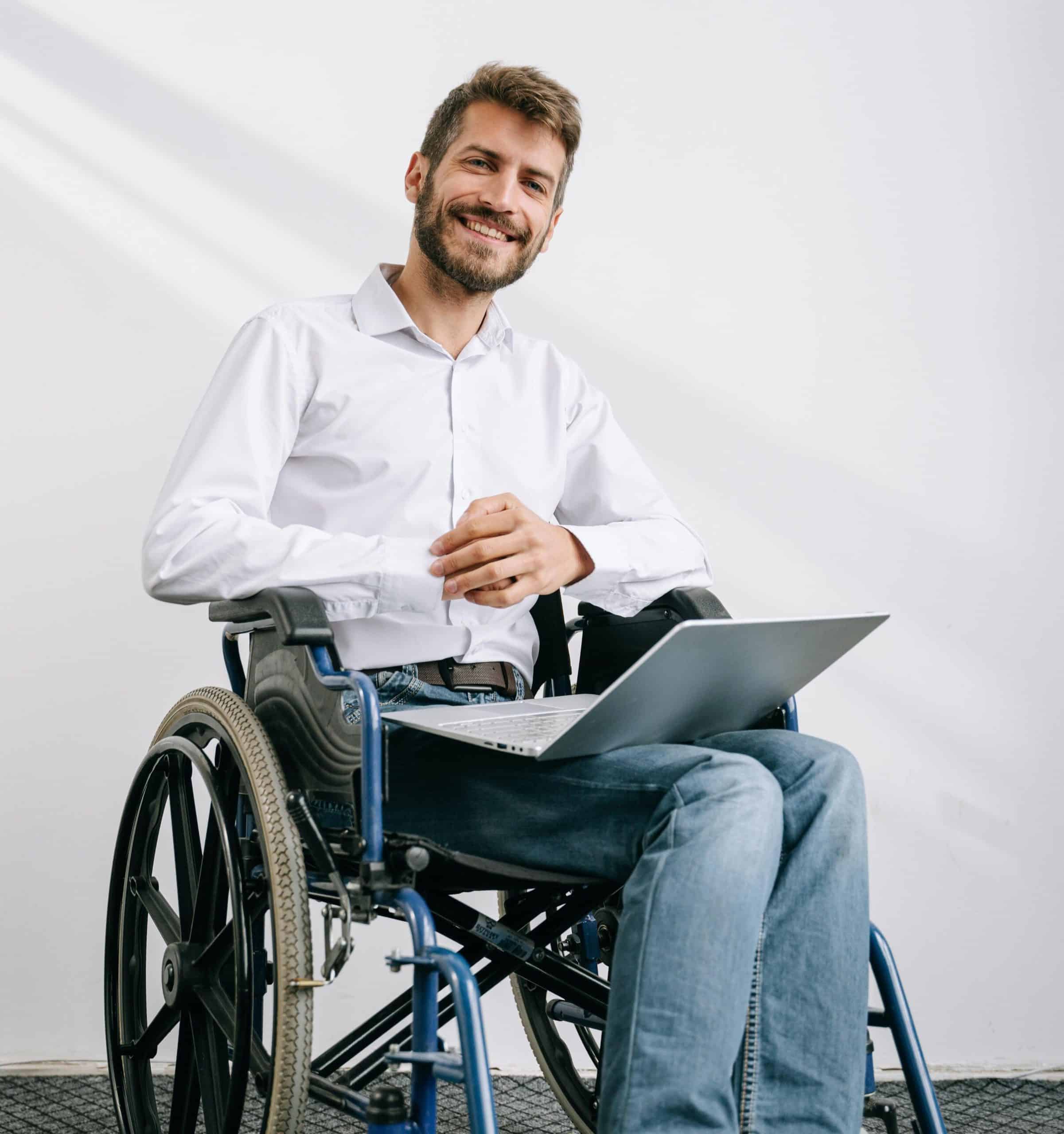 A couple sat in their wheelchairs on paving, they are looking at a church with many people walking towards them. They are feeling better after having spinal cord injury counselling