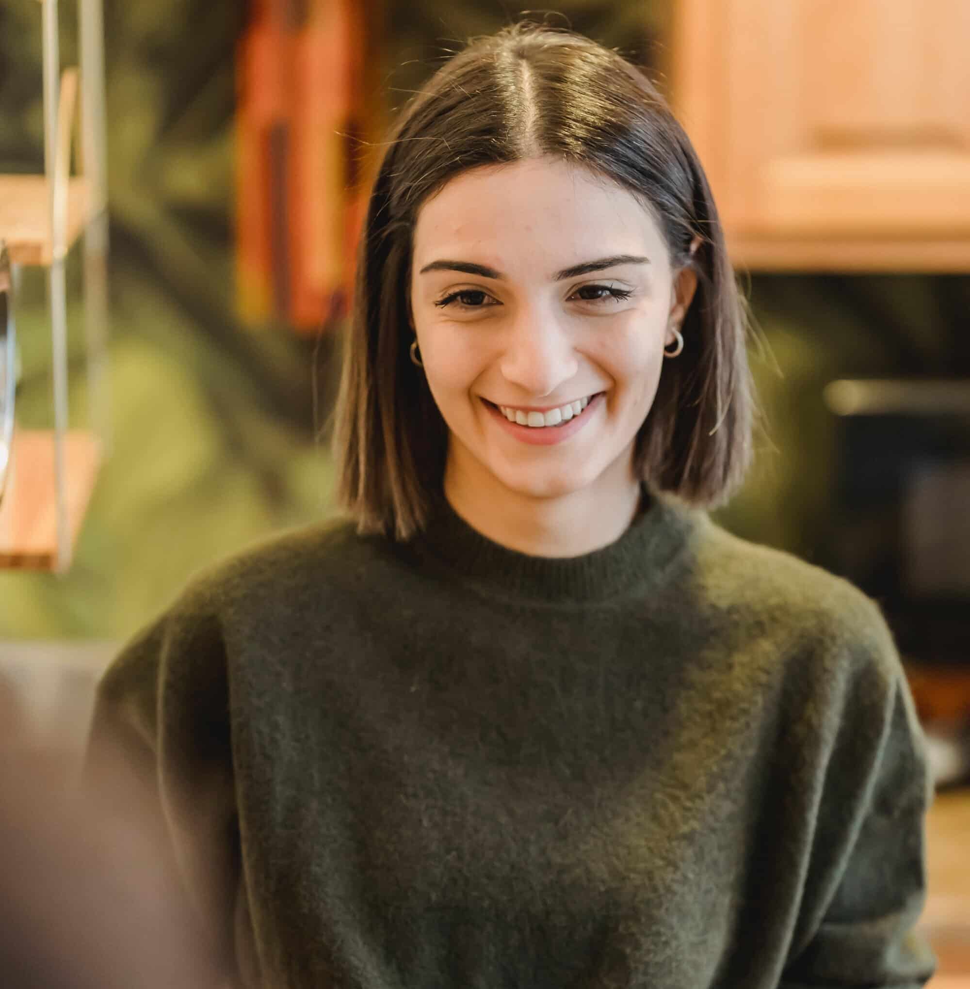 A lady stood in the kitchen making some cakes, her daughter is stood behind her smiling as her mother has started tinnitus counselling.