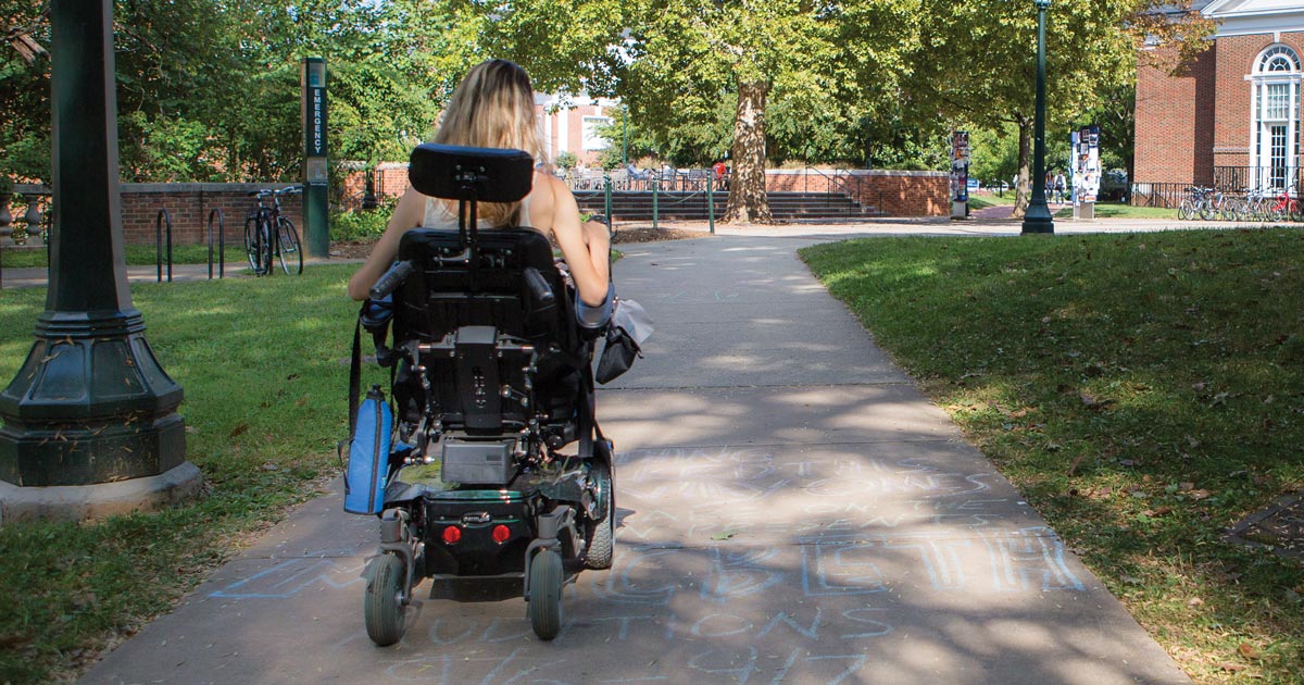 A man sat in his wheelchair with a laptop in front of him. He has had a accident which has resulted to him having spinal cord injury counselling