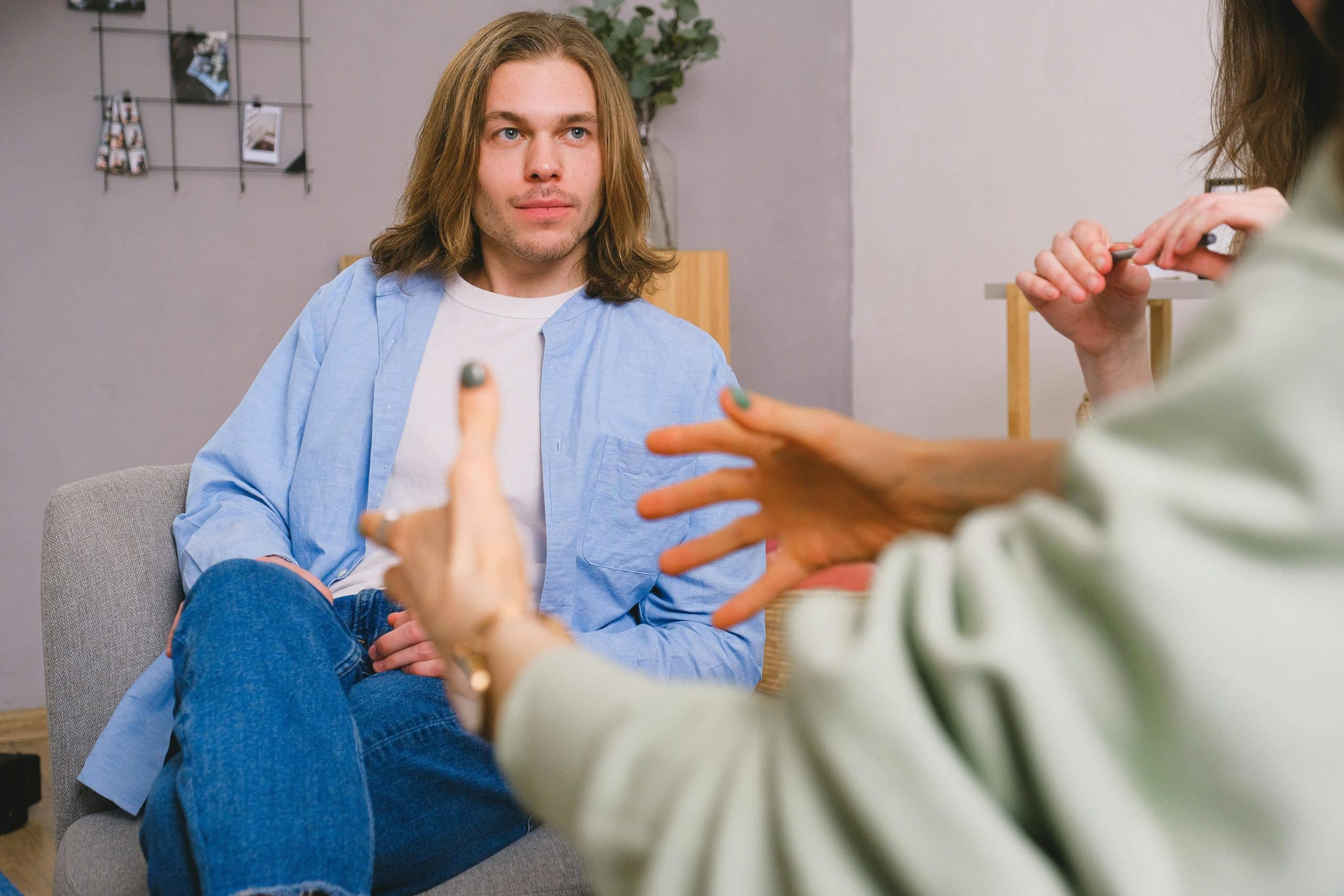 Lady sat at her desk with red coat on, she sat in a wheelchair, this picture presents cerebral palsy counselling.